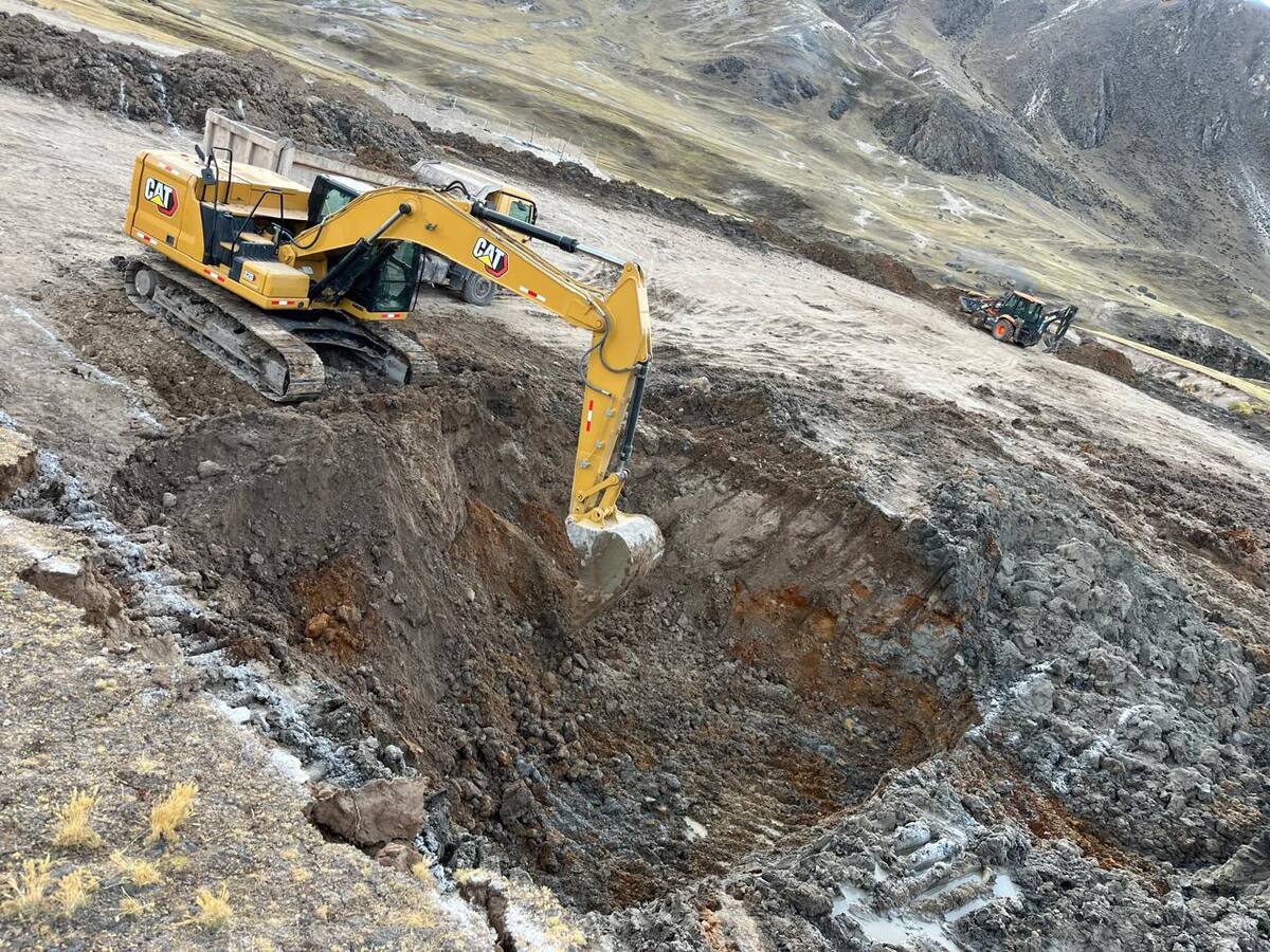Excavadora CAT cavando zanja profunda en movimiento de tierra